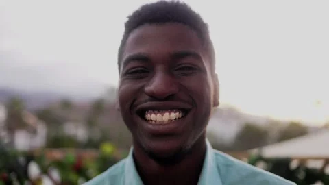 Authentic African young man smiling at camera with sunset background Stock Footage 244145951