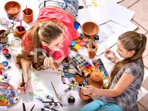 Authentic artist children girl paints on floor. Top view. Stock Photos