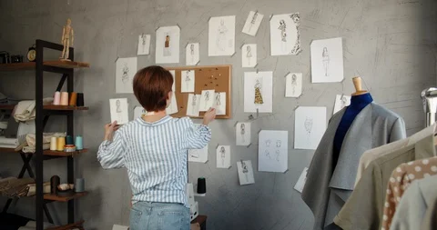 Authentic asian clothes designer is working at her office, looking at sketches Stock Footage 127856379