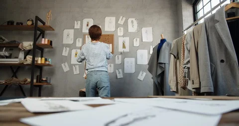 Authentic asian clothes designer is working at her office, looking at sketches Stock Footage 128082647