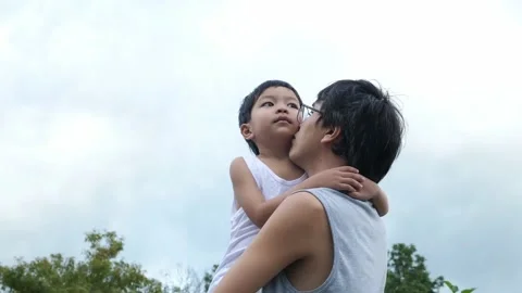Authentic asian cute child boy in hug of father pointing finger to sky. Stock Footage