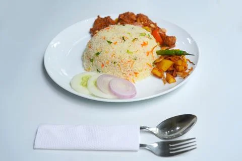Authentic Asian Fried Rice Served with Devil Chicken on White Plate with spoon Stock Photos