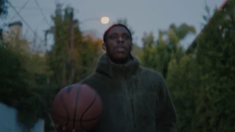 Authentic Black man walk at dusk with basketball Stock Footage 170131686