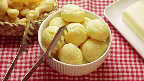 Authentic Brazilian cheese bread being removed from a white ceramic bowl Stock Footage 337274656