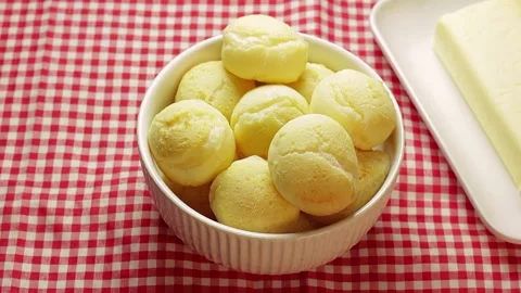 Authentic Brazilian cheese bread in a white ceramic bowl, with a plate Stock Footage 337274632