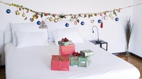 Authentic Chrismas presents on top of bed with suspend decoration. Video stock 102658081