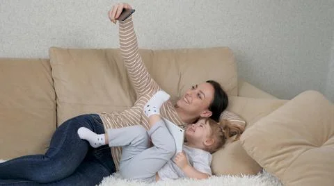 Authentic close up of neo mother and her baby making a selfie or video call to Stock Photos