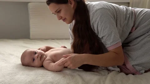 Authentic close up shot young neo mother mum is playing with nake newborn child Vídeos de archivo 164721276