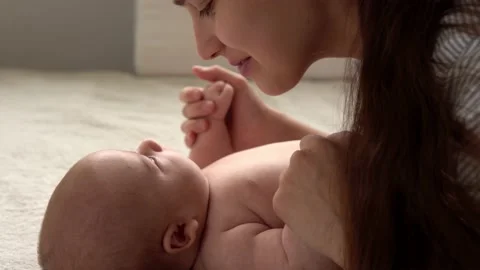 Authentic close up shot young neo mother mum is playing with nake newborn child Vídeos de archivo 164721419
