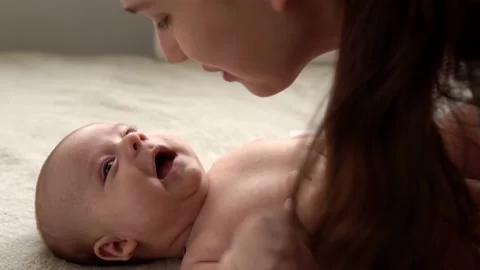 Authentic close up shot young neo mother mum is playing with nake newborn child Vídeos de archivo 166026514