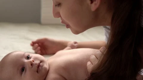 Authentic close up shot young neo mother mum is playing with nake newborn child Stock Footage 166926112