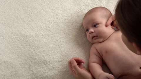 Authentic close up shot young neo mother mum is playing with nake newborn child Stock Footage 166926257