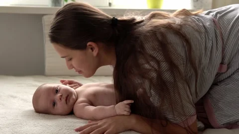 Authentic close up shot young neo mother mum is playing with nake newborn child Vídeos de archivo 166926642
