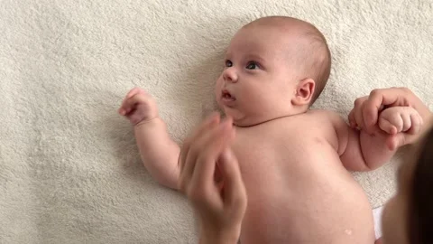 Authentic close up shot young neo mother mum is playing with nake newborn child Stock Footage 167035629