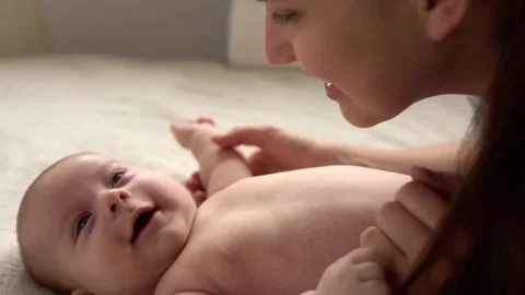 Authentic close up shot young neo mother mum is playing with nake newborn child Stock Footage 167035782