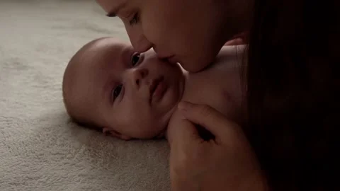 Authentic close up shot young neo mother mum is playing with nake newborn child Vídeos de archivo 167324178
