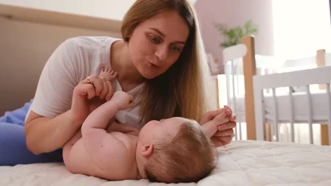 Authentic close up shot of young neo mother is playing with her newborn baby Stock Footage 202639496