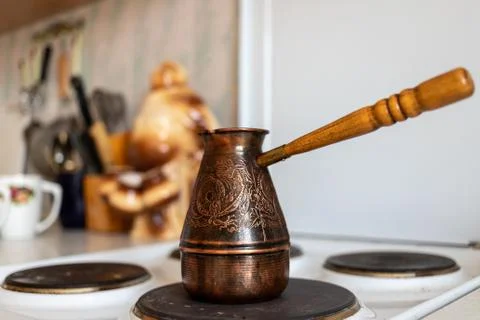 An authentic coffee maker stands on the stove of an ordinary kitchen, with two Stock-Fotos