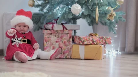 Authentic cute happy Joy chubby infant girl wearing santa hat and red dress Video stock 152878762