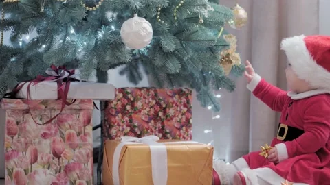 Authentic cute happy Joy chubby infant girl wearing santa hat and red dress Video stock 153158403