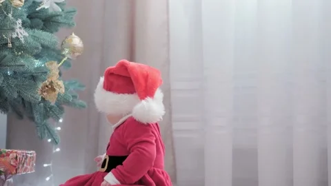Authentic cute happy Joy chubby infant girl wearing santa hat and red dress Stock Footage 153939973