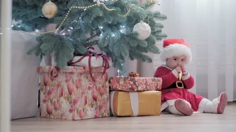 Authentic cute happy Joy chubby infant girl wearing santa hat and red dress Stock Footage 154185219