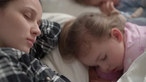 Authentic cute young mom fell asleep read fairy tale from book to baby before Stock Footage 156137855