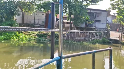 Authentic daily life scenery of a rustic riverside settlement viewed Stock Footage 347111231