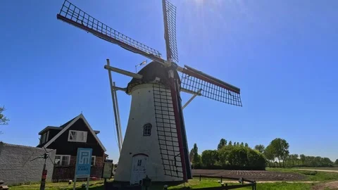 Authentic Dutch windmill illuminated by bright sunlight beneath a clear blu.. Stock Footage 340227829
