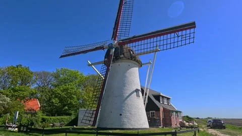 Authentic Dutch windmill illuminated by bright sunlight beneath a clear blu.. Stock Footage 340227940