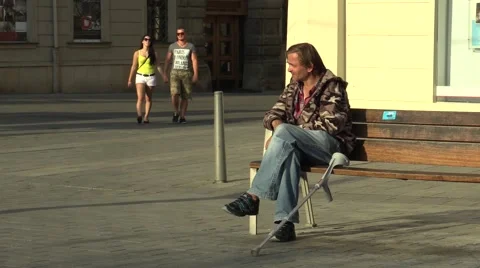 Authentic emotion handicapped homeless man sitting on a bench and eating Stock Footage 52361008