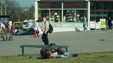 Authentic emotion homeless drunk man sleep in on street, people walk Stock Footage 106252487