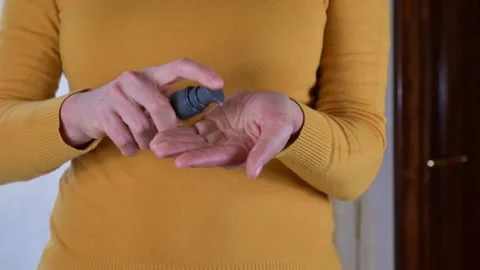 Authentic female hands are using sanitizer gel for coronavirus spread prevention Stock Footage 131557570