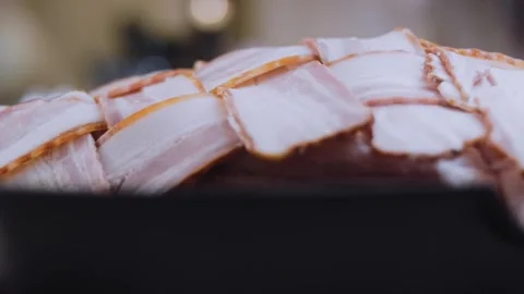 Authentic finished dish: placing bacon wrapped pork in a roasting pan Stock Footage 342184811