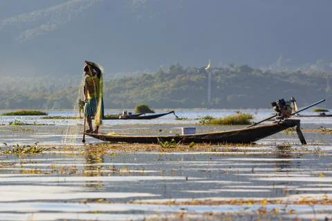 Authentic fishermen working checking their nets on the waters of Inle Lake. Stock Photos