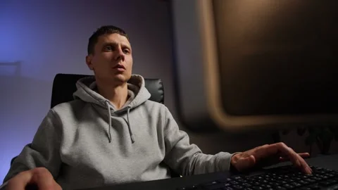 Authentic gamer at home playing computer game, emotional young man immersed in Stock Footage 315407608