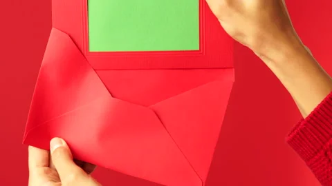 Authentic gift. Close up of female hands putting a letter in red envelope Stock Footage 146129118