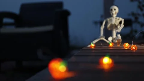 Authentic Halloween terraced setup with small LED pumpkins and a skeleton prop Stock Footage 344039670