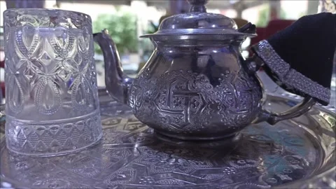 Authentic Hand-Carved Moroccan Silver-Plated Tea Pot and Glass Set Stock Footage 334136198