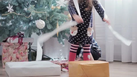 Authentic happy Joy children open box with gifts rejoice by Christmas tree play Stock Footage 152879419