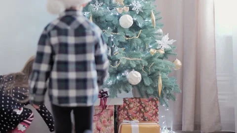 Authentic happy Joy children open box with gifts rejoice by Christmas tree play Stock Footage 155653932