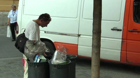 Authentic homeless man looking and eats food from the trash bin Stock Footage 55336339