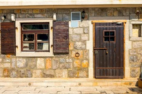 Authentic house with a stone wall, with a beautiful old window and  shutters Stock Photos