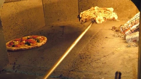 Authentic Italian pizza baking in a traditional stone wood-fired oven with burni Stock Footage 337678809