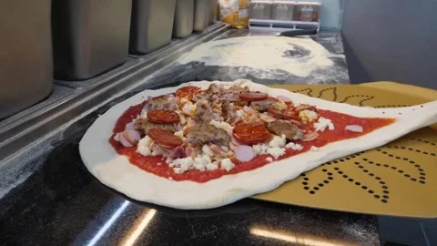 Authentic Italian Pizzaiolo Preparing Raw Pizza with Fresh Toppings on a Peel in Stock Footage 337676646