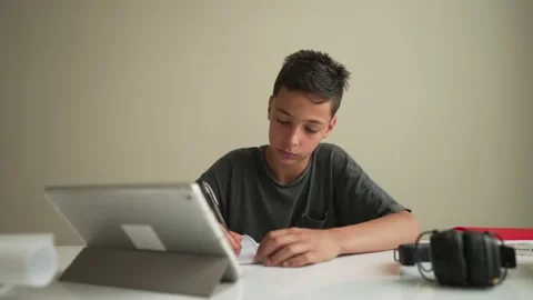 Authentic Kid doing online homework with friends at home, Child using tablet for 스톡 동영상 195253825