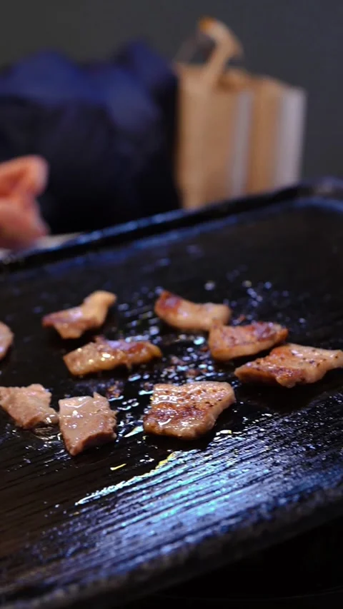 Authentic Korean BBQ close-up: Samgyeopsal sizzling on a griddle Stock Footage 333740374