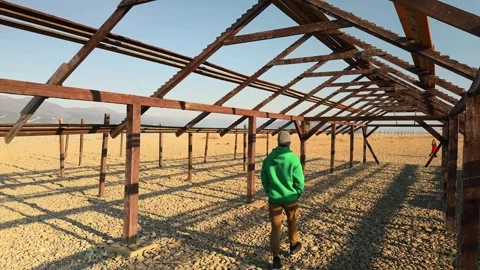 Authentic Man Walking Into Distance Through Wooden Geometric Frame On Pebbl.. 스톡 동영상 330857449