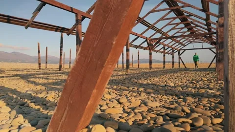 Authentic Man Walking Forward Toward Camera Past Weathered Foreground Beam .. 스톡 동영상 330857358