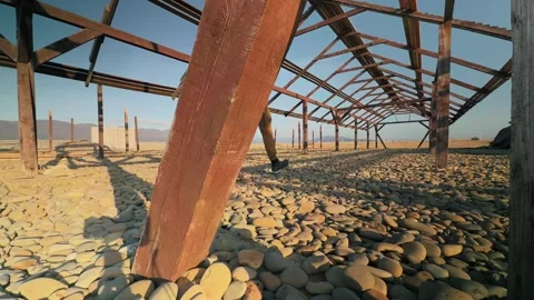 Authentic Man Walking Past Foreground Wooden Beam Into Symmetrical Abandone.. 스톡 동영상 330857451